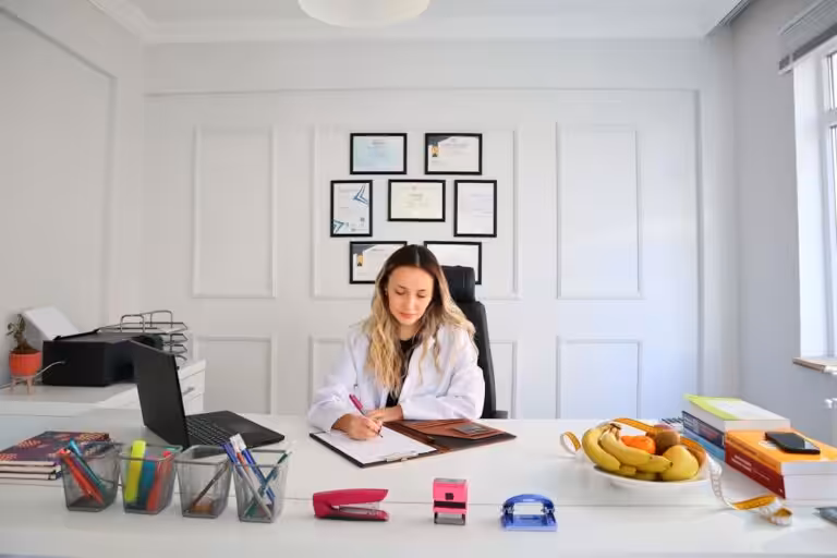 a woman sitting at a desk in front of a laptop