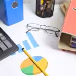 Desk with calculator, charts, and binders