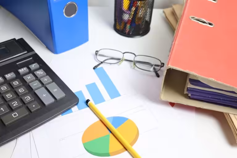 Desk with calculator, charts, and binders