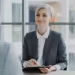 Woman in suit interviews man across table