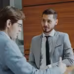 Two businessmen shaking hands in modern office