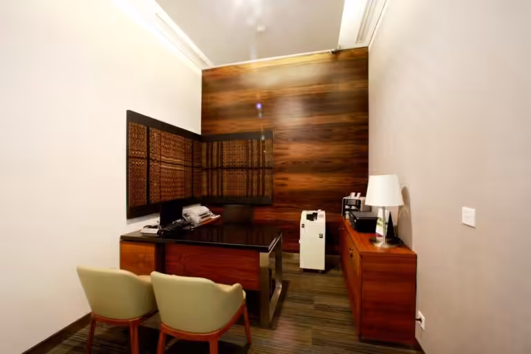A modern office with desk and wooden furniture