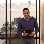 a man standing in an office looking at a tablet