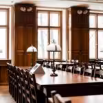 a long table with chairs and lamps in a room