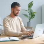 Man typing on laptop at a desk