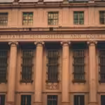 A large building with columns and a clock on the front of it
