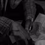 grayscale photo of person writing on paper