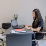 Woman working on laptop at desk in office